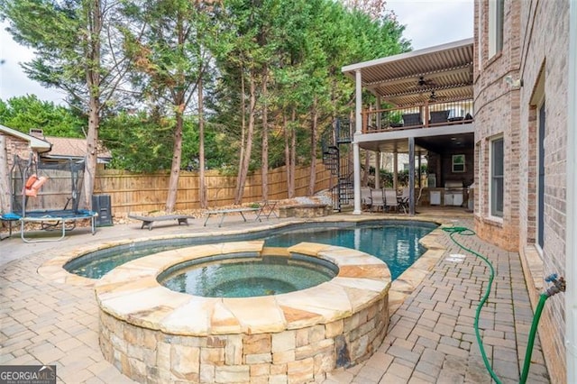 view of pool featuring an in ground hot tub, ceiling fan, a patio, and a trampoline