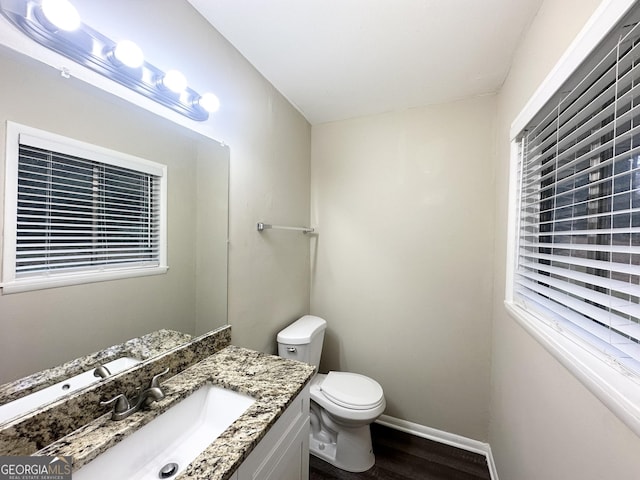 bathroom featuring wood-type flooring, vanity, and toilet