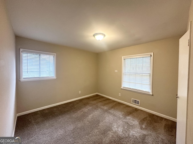 unfurnished room featuring a wealth of natural light and carpet