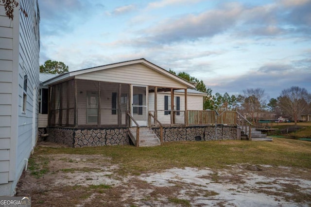 view of front of house with a sunroom and a front yard