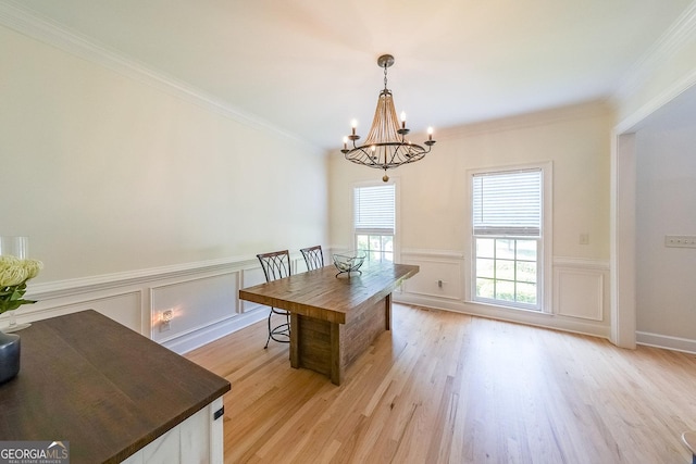 dining room featuring light hardwood / wood-style flooring, a chandelier, and ornamental molding