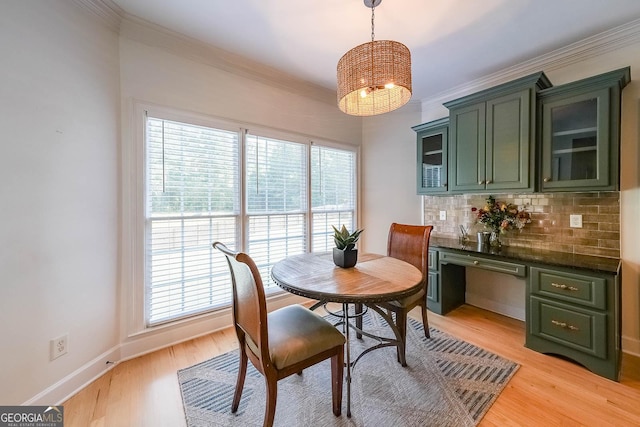 dining room featuring light wood-type flooring, plenty of natural light, and ornamental molding