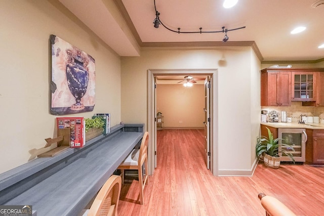 hallway with light hardwood / wood-style flooring, wine cooler, and ornamental molding