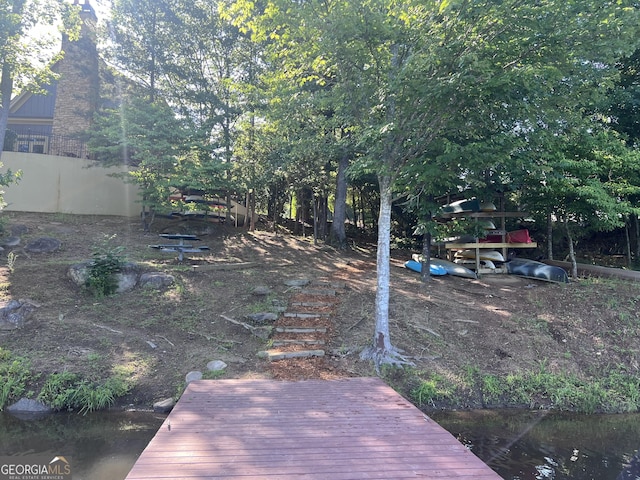 view of yard featuring a water view and a dock