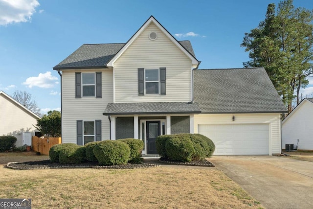 front facade with central AC, a front yard, and a garage