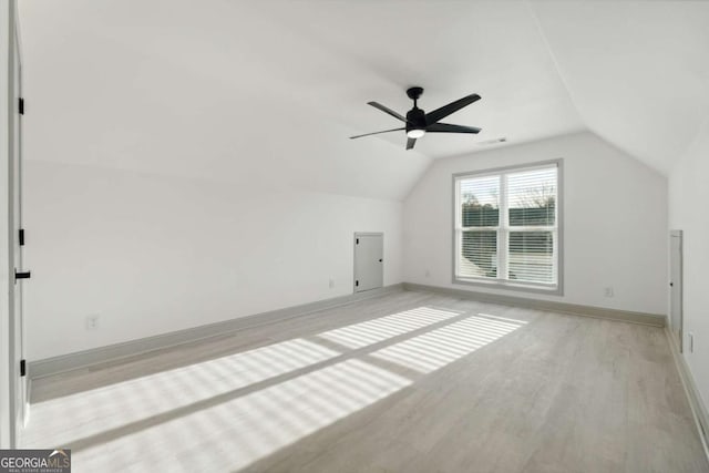 additional living space with ceiling fan, light wood-type flooring, and vaulted ceiling