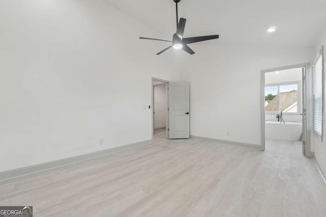 interior space with light hardwood / wood-style floors, high vaulted ceiling, and ceiling fan