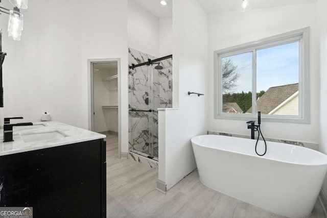 bathroom with vanity, hardwood / wood-style flooring, and separate shower and tub