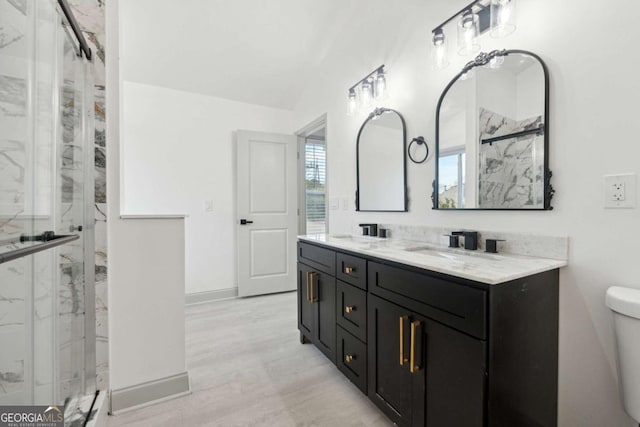 bathroom featuring vanity, wood-type flooring, an enclosed shower, and toilet