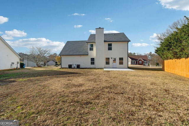 back of house featuring a lawn, central air condition unit, and a patio