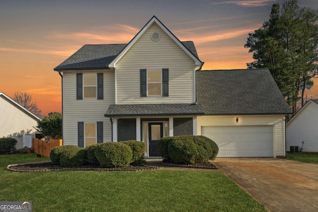 view of front property with central AC unit, a garage, and a lawn