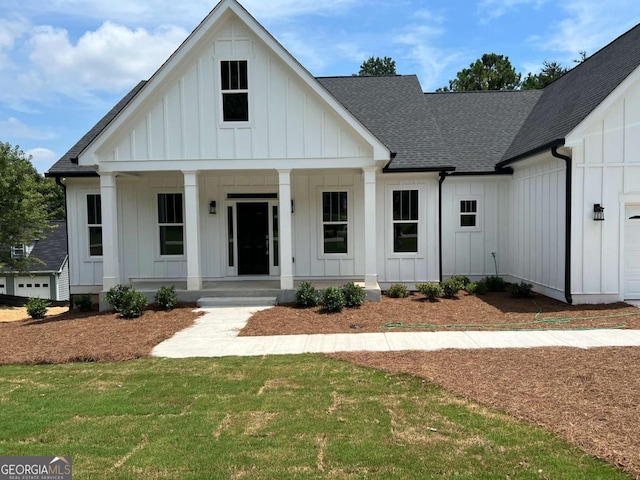 modern farmhouse with a front lawn and a porch