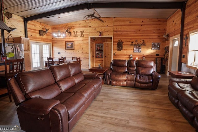 living room featuring wood-type flooring, wooden walls, lofted ceiling with beams, and a healthy amount of sunlight