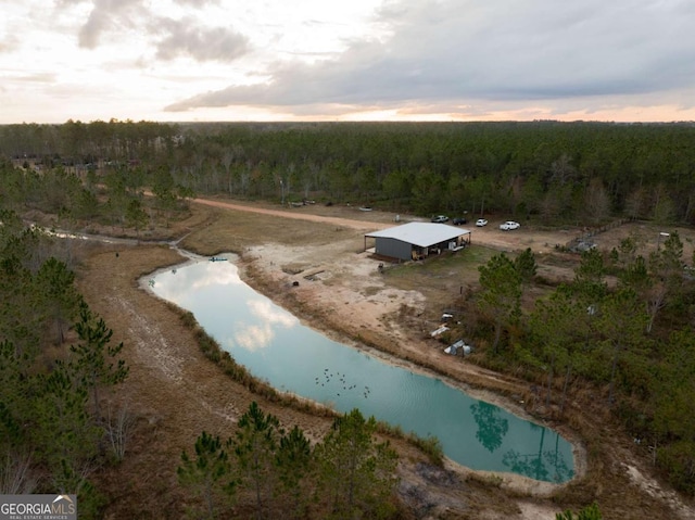 aerial view at dusk featuring a water view