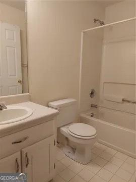 full bathroom featuring bathing tub / shower combination, tile patterned floors, vanity, and toilet