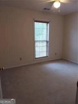 empty room featuring ceiling fan and carpet floors