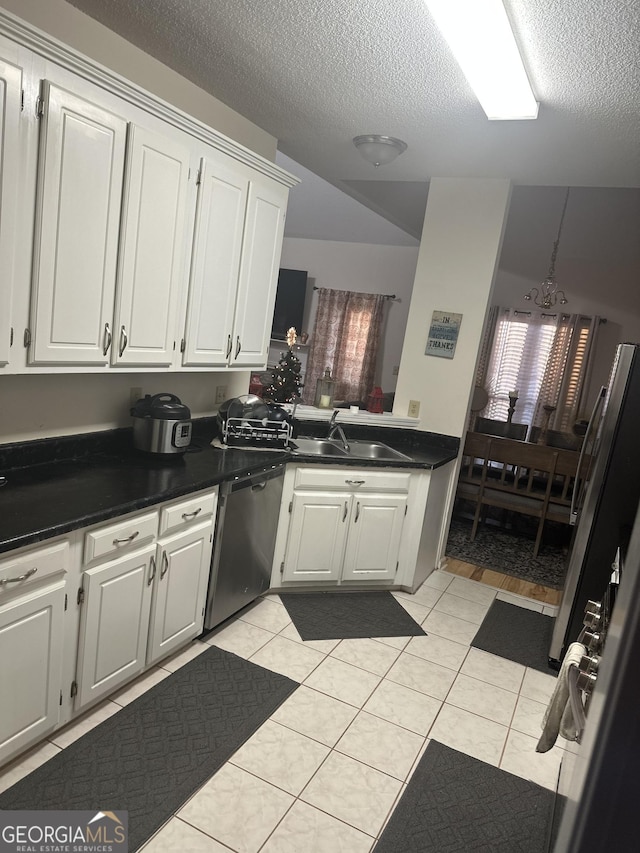 kitchen with light tile patterned floors, white cabinetry, stainless steel dishwasher, and sink