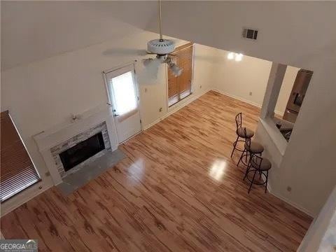 unfurnished living room with heating unit, light hardwood / wood-style floors, and ceiling fan