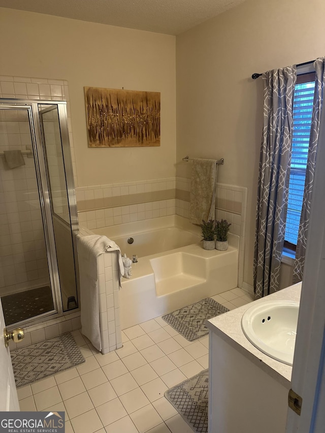 bathroom featuring tile patterned flooring, vanity, and plus walk in shower