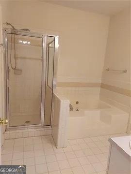 bathroom with tile patterned floors, vanity, and shower with separate bathtub