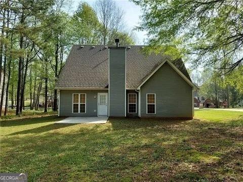 back of house featuring a patio area and a lawn