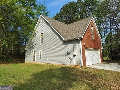 view of side of home featuring a yard and a garage