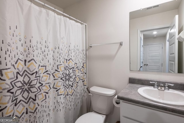 bathroom featuring a shower with shower curtain, vanity, and toilet