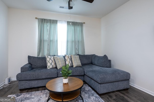 living room featuring ceiling fan and dark wood-type flooring