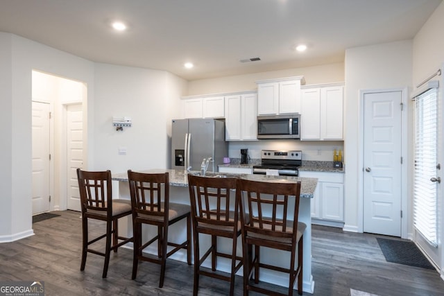 kitchen with white cabinetry, plenty of natural light, a center island with sink, and appliances with stainless steel finishes