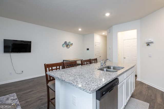 kitchen with dark wood-type flooring, sink, dishwasher, white cabinetry, and an island with sink