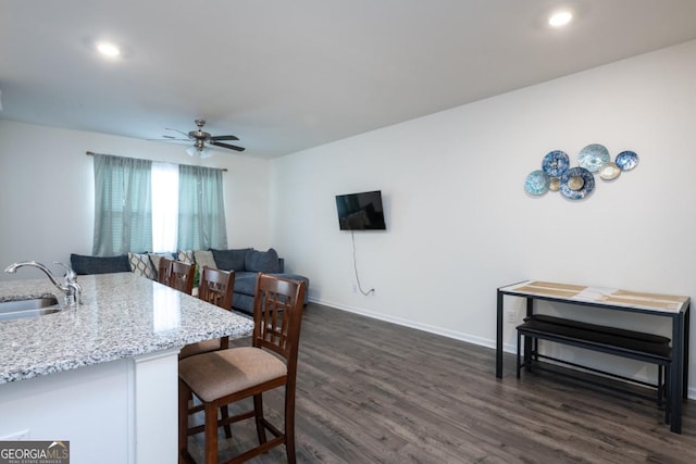 dining room featuring dark hardwood / wood-style flooring, ceiling fan, and sink