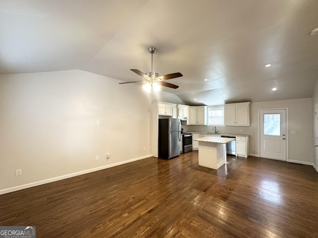 kitchen with dark hardwood / wood-style flooring, stainless steel appliances, sink, white cabinets, and a center island