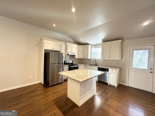 kitchen with appliances with stainless steel finishes, a kitchen island, plenty of natural light, and lofted ceiling