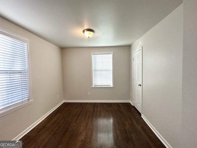 unfurnished room with dark hardwood / wood-style flooring