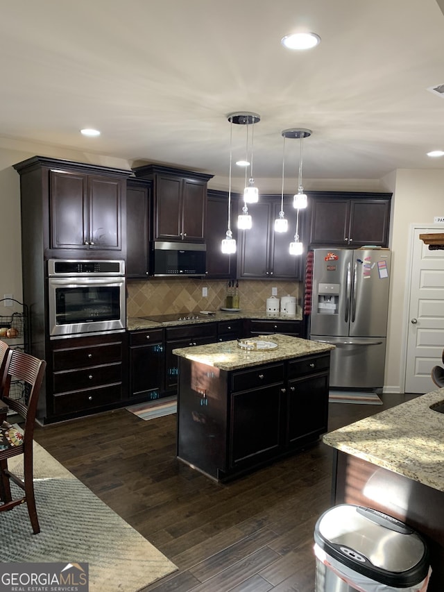 kitchen featuring hanging light fixtures, light stone counters, dark hardwood / wood-style floors, a kitchen island, and appliances with stainless steel finishes