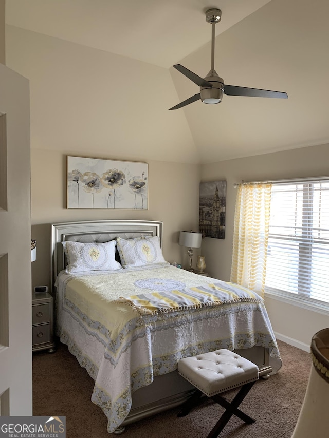 bedroom with ceiling fan, lofted ceiling, and dark colored carpet