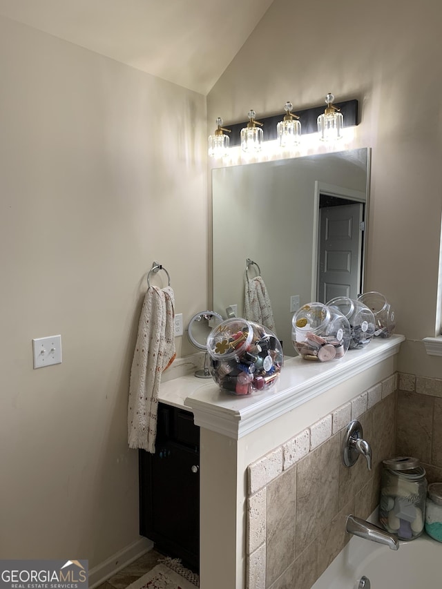 bathroom with vanity and lofted ceiling