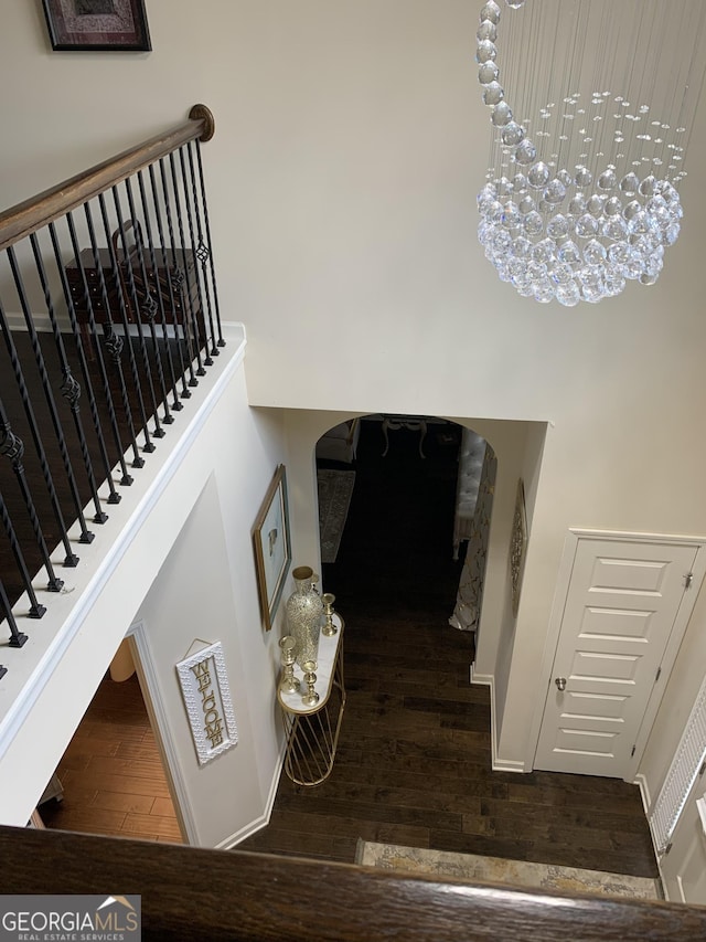 stairs featuring hardwood / wood-style flooring and a notable chandelier