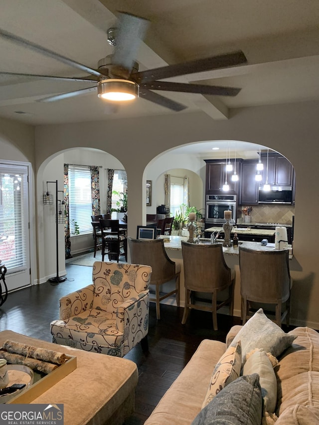 living room with dark hardwood / wood-style floors and ceiling fan