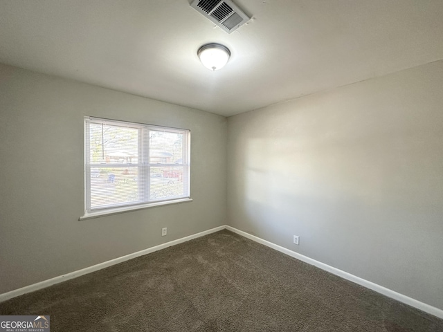 empty room featuring dark carpet