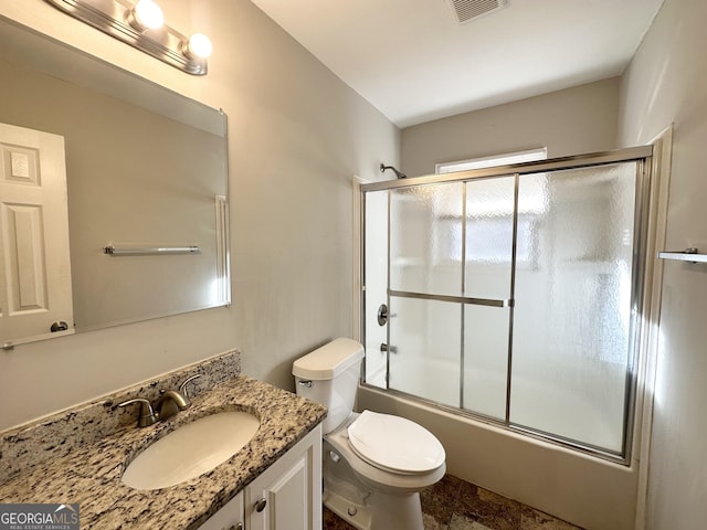 full bathroom featuring toilet, vanity, and combined bath / shower with glass door