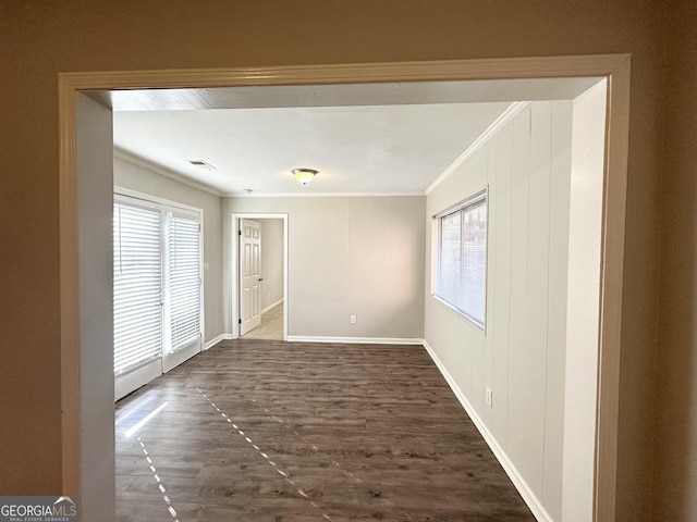 spare room with dark hardwood / wood-style flooring and crown molding