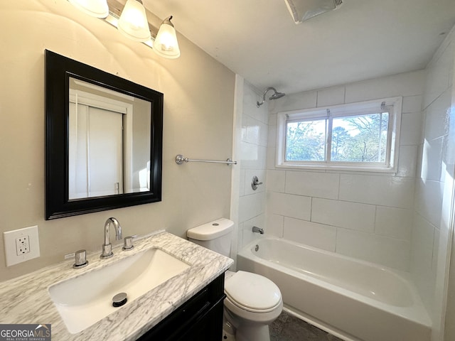 full bathroom featuring tiled shower / bath, vanity, and toilet