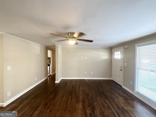 empty room featuring ceiling fan, crown molding, and dark wood-type flooring