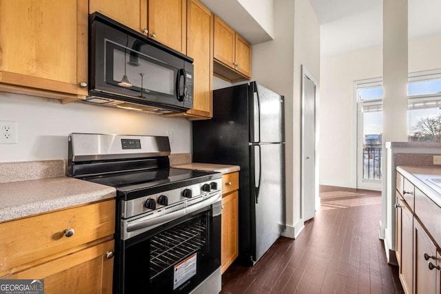 kitchen featuring black appliances and dark hardwood / wood-style floors