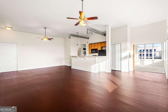 unfurnished living room with dark hardwood / wood-style flooring and ceiling fan