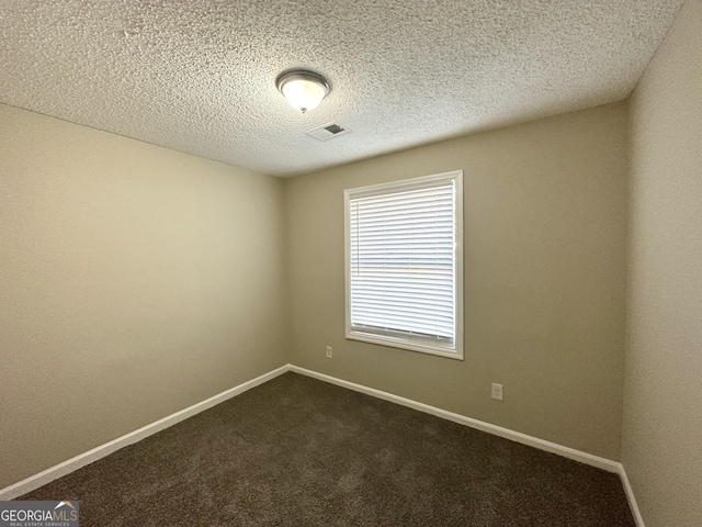 carpeted empty room with a textured ceiling