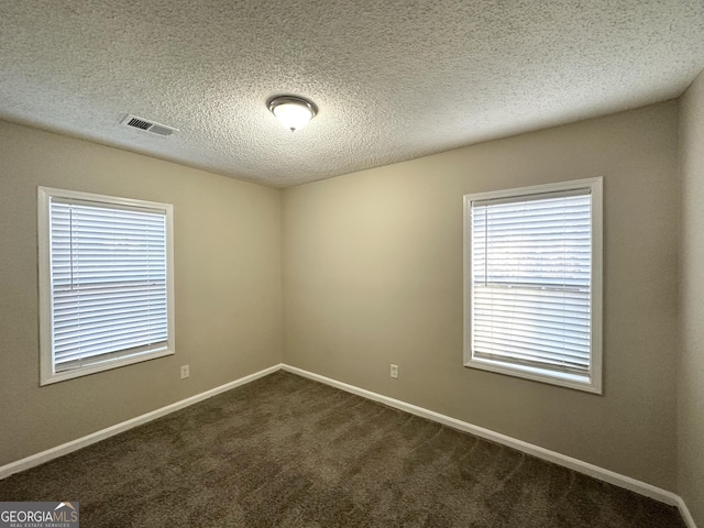 carpeted empty room with a textured ceiling