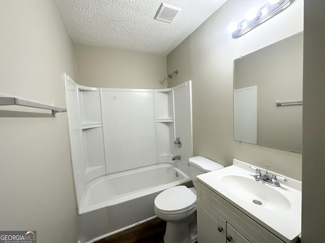 full bathroom with vanity, a textured ceiling, hardwood / wood-style flooring, washtub / shower combination, and toilet