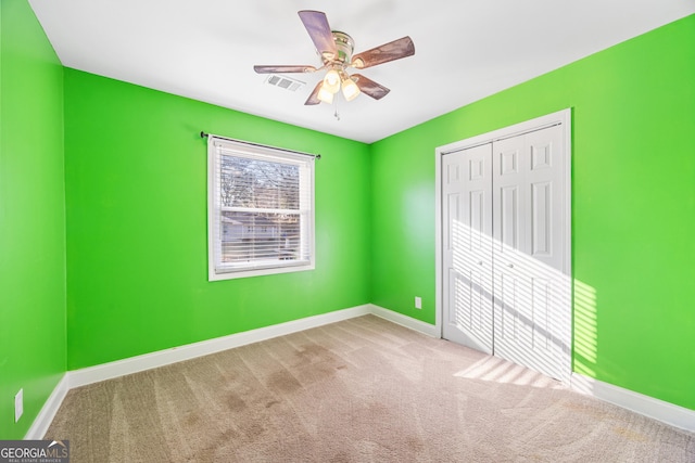 unfurnished bedroom featuring ceiling fan, a closet, and carpet floors